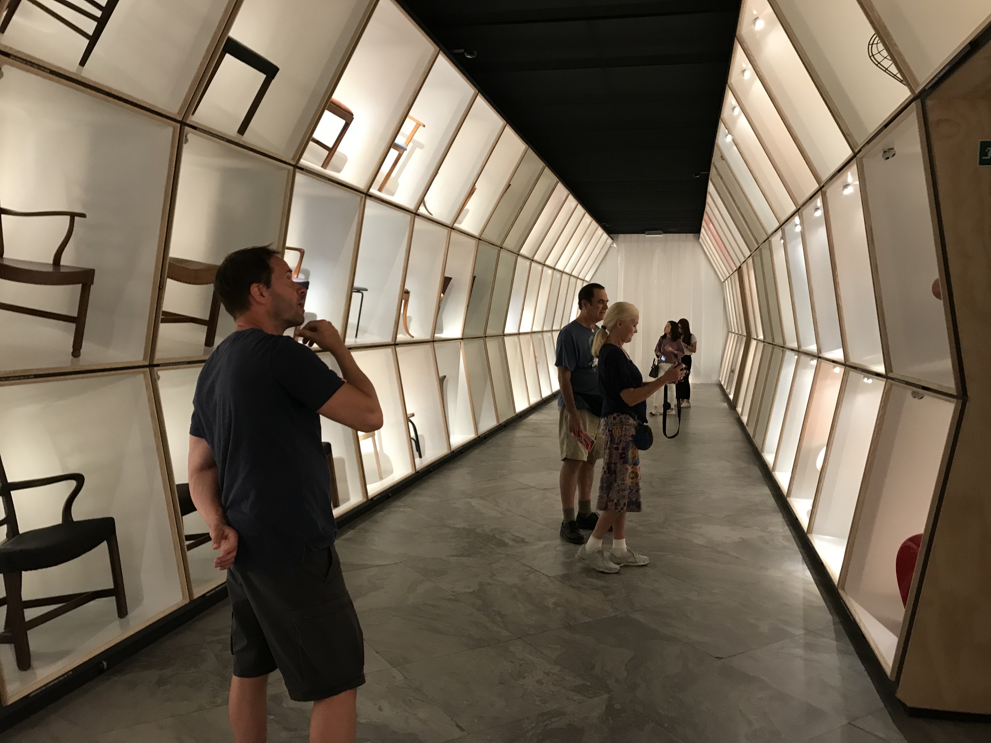 Long view of the chair hall at the Danish design museum, showing rows of iconic Danish chair designs
